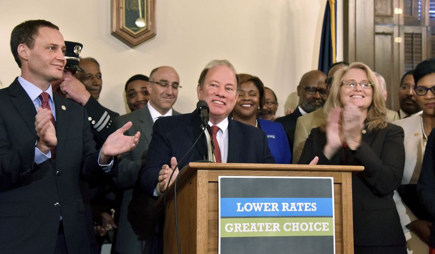 Speaker of the Michigan House Tom Leonard, R-Dewitt, left, Detroit Mayor Mike Duggan, and Rep. Lana Theis, R-Brighton, right, chair of the House Committee on Insurance, announce bi-partisan legislation designed to reduce Michigan drivers&#x27; insurance payments Tuesday, Sept. 26, 2017, in Lansing, Mich. (Dale G Young/Detroit News via AP)