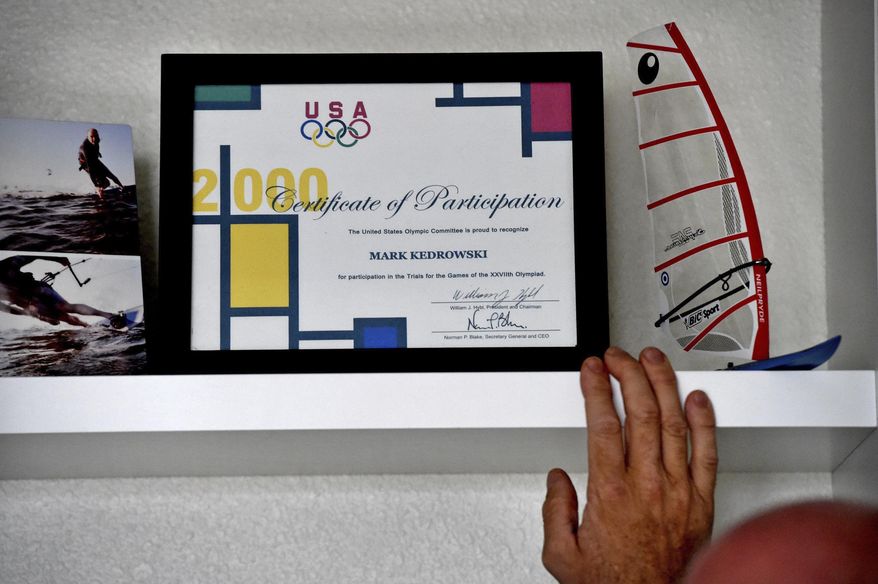 In this Sept. 6, 2017 photo, Mark Kedrowski looks over a framed Certificate of Participation from the 1999 Olympic Trials in his White Bear Lake, Minn. home. In 1999, he qualified for the U.S. Olympic Trials in windsurfing. Kedrowski, 46, was nearly killed in 2010 when the plane he was piloting crashed shortly after takeoff from the Lake Elmo airport. Kedrowski, who said the plane was losing power before the crash, sued the designer of the plane's fuel pump, Lycoming Engines, and its manufacturer, Kelly Aerospace Power Systems. A jury awarded him $27.7 million in the case, which was then overturned by a judge. Kedrowski has filed an appeal with the Minnesota Court of Appeals. (Jean Pieri /Pioneer Press via AP)
