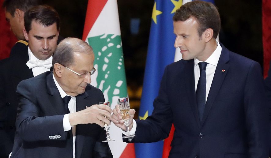 Lebanese President Michel Aoun, left, and French President Emmanuel Macron make a toast during a dinner at the Elysee Palace in Paris, France, Monday, Sept. 25, 2017. (Etienne Laurent/Pool Photo via AP)