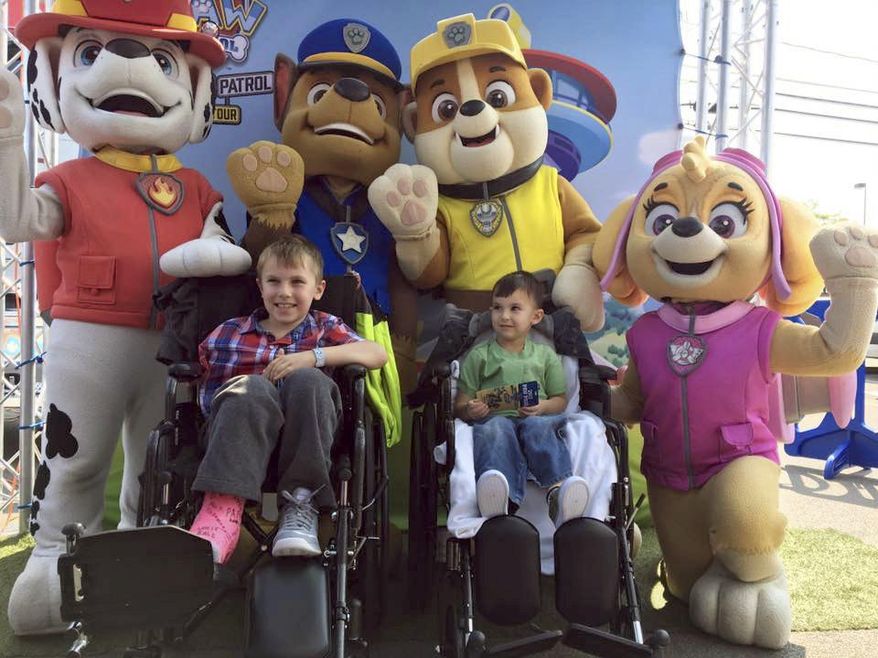In this Sept. 10, 2017 photo provided by Nicole Miller, seven-year-old Jacob Green, center left, and his brother, four-year-old Alexander, are surrounded by costumed actors as they are discharged from a hospital in Orchard Park, N.Y. The brothers were injured after falling off a 200-foot cliff along with their parents on Aug. 20. Both parents died in the accident. (Nicole Miller via AP)