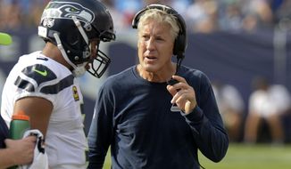 FILE - In this Sept. 24, 2017, file photo, Seattle Seahawks head coach Pete Carroll talks with quarterback Russell Wilson in the first half of an NFL football game against the Tennessee Titans in Nashville, Tenn. Almost all of the 200 players who took part in protests during Sunday&#39;s NFL games were doing so for the first time, but not just because President Donald Trump suggested team owners should &amp;quot;fire &#39;em.&amp;quot; Seattle coach Carroll and linebackers Von Miller and Lorenzo Alexander discussed, in their own words, how they became &amp;quot;woke.&amp;quot; (AP Photo/Mark Zaleski, File)