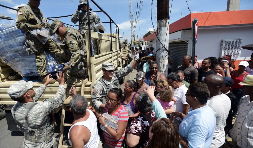 National Guardsmen arrive at Barrio Obrero in Santurce to distribute water and food among those affected by the passage of Hurricane Maria, in San Juan, Puerto Rico, Sunday, Sept. 24, 2017. Puerto Rico&#x27;s nonvoting representative in the U.S. Congress said Sunday that Hurricane Maria&#x27;s destruction has set the island back decades, even as authorities worked to assess the extent of the damage. (AP Photo/Carlos Giusti)