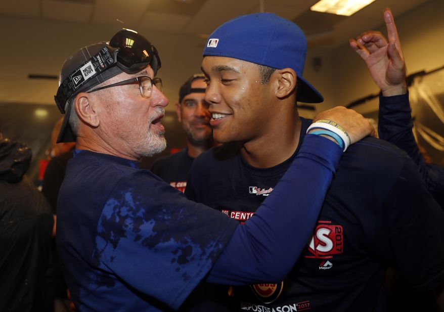 Chicago Cubs manager Joe Maddon, left, and shortstop Addison Russell celebrate after defeating the St. Louis Cardinals in a baseball game to clinch the National League Central title Wednesday, Sept. 27, 2017, in St. Louis. (AP Photo/Jeff Roberson)