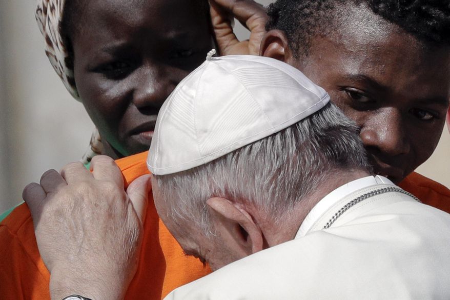 Pope Francis embraces a migrant, during his weekly general audience, at the Vatican, Wednesday, Sept. 27, 2017. Pope Francis on Wednesday launched a two-year activism and awareness-raising campaign about the plight of migrants to counteract mounting anti-immigrant sentiment in the U.S., Europe and beyond. (AP Photo/Andrew Medichini)
