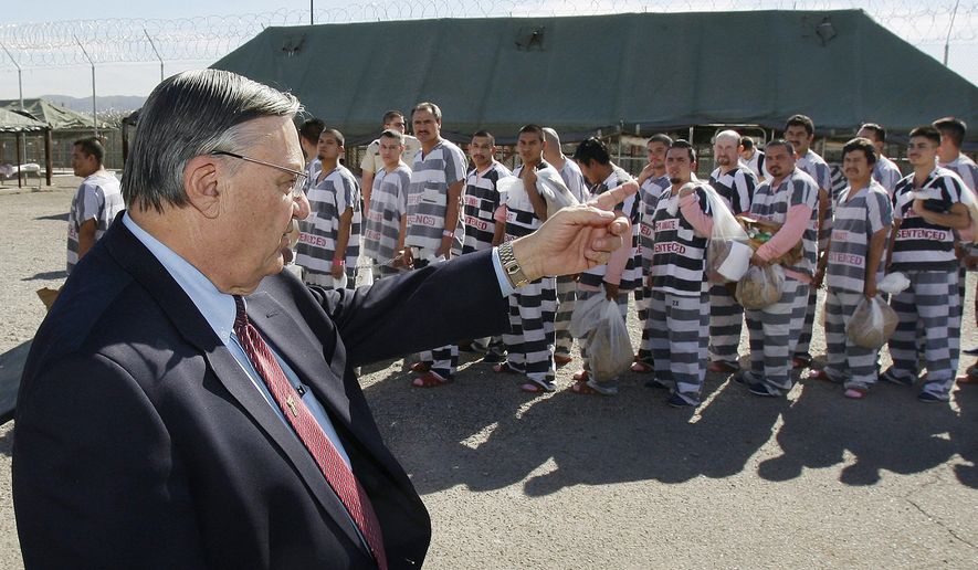 FILE - In this Feb. 4, 2009, file photo, Maricopa County Sheriff Joe Arpaio, left, orders approximately 200 convicted illegal immigrants handcuffed together and moved into a separate area of Tent City, for incarceration until their sentences are served and they are deported to their home countries, in Phoenix. An audit report produced in a racial profiling case against the Maricopa County Sheriff&#x27;s Office says Hispanics are more likely to be searched and arrested by sheriff&#x27;s deputies in traffic stops than white people. The report was issued nearly four years after a judge ordered a sweeping overhaul of then-Sheriff Joe Arpaio&#x27;s office after concluding officers had racially profiled Hispanics in immigration patrols. (AP Photo/Ross D. Franklin, File)