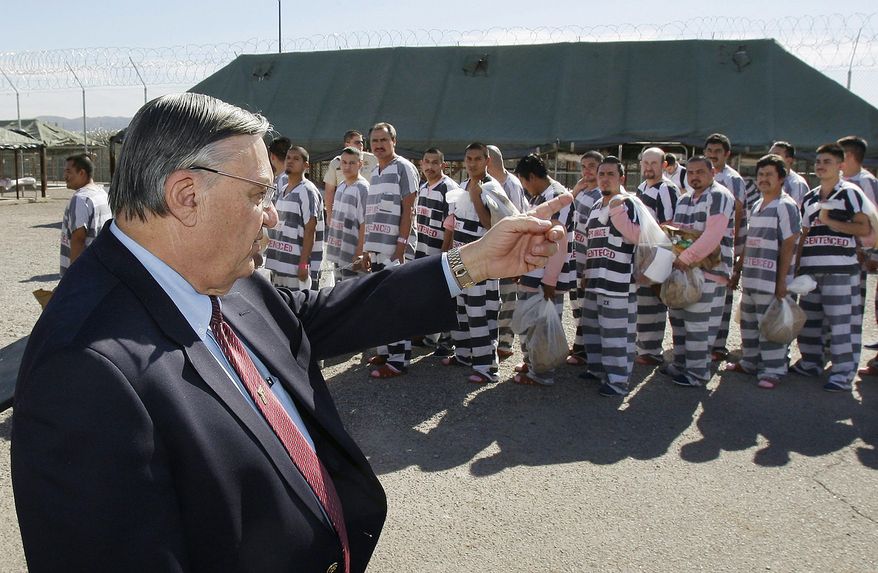 FILE - In this Feb. 4, 2009, file photo, Maricopa County Sheriff Joe Arpaio, left, orders approximately 200 convicted illegal immigrants handcuffed together and moved into a separate area of Tent City, for incarceration until their sentences are served and they are deported to their home countries, in Phoenix. An audit report produced in a racial profiling case against the Maricopa County Sheriff&#x27;s Office says Hispanics are more likely to be searched and arrested by sheriff&#x27;s deputies in traffic stops than white people. The report was issued nearly four years after a judge ordered a sweeping overhaul of then-Sheriff Joe Arpaio&#x27;s office after concluding officers had racially profiled Hispanics in immigration patrols. (AP Photo/Ross D. Franklin, File)