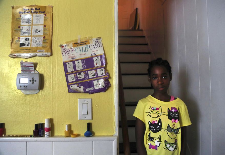 In this July 28, 2017, photo, Kathleen, 12, a disabled adopted daughter of Vivian Shine-King, poses for a portrait at her home in Philadelphia. For foster parents of disabled children, money is getting tighter. The reimbursements are seen as crucial because the high costs of caring for such children makes it less likely they'll ever be adopted. Philadelphia, Missouri and Oklahoma are among places giving payments to foster parents of disabled children a closer look. (AP Photo/Jacqueline Larma)
