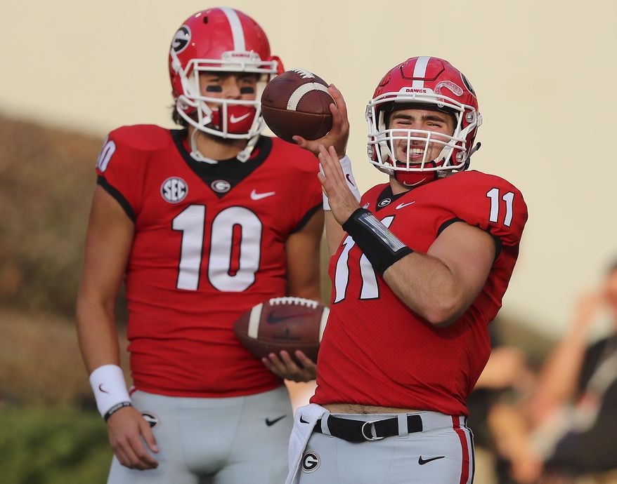 FILE - In this Saturday, Sept. 23, 2017, file photo, injured Georgia quarterback Jacob Eason, left, watches as Jake Fromm warms up for the team's NCAA college football game against Mississippi State in Athens, Ga. Georgia freshman Jake Fromm has played so well in place of the injured Jacob Eason that the seventh-ranked Bulldogs must decide what to do once Eason is healthy again. (Curtis Compton/Atlanta Journal-Constitution via AP, File)