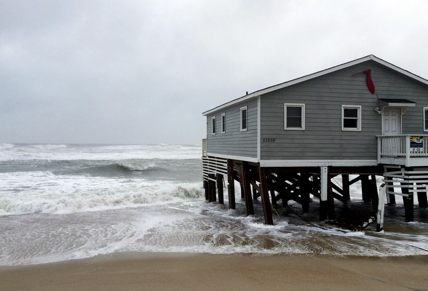 Waves wash ashore hitting a house as winds and storm surge from Tropical Storm Maria lash North Carolinas Outer Banks as the storm moves by well off-shore on Wednesday, Sept. 27, 2017. Dare County officials said the high tide flooded some roads in the area and travel is hazardous. (AP Photo/Ben Finley)