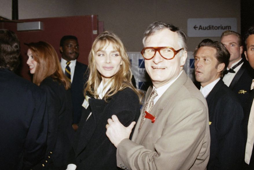 Hugh Hefner, right, poses with his wife Kimberly Hefner, center, in 1993. (AP Photo)