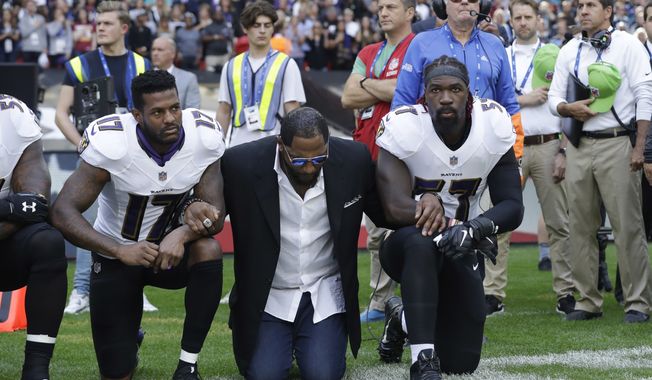 FILE - In this Sunday Sept. 24, 2017, file photo, Baltimore Ravens wide receiver Mike Wallace, from left, former player Ray Lewis and inside linebacker C.J. Mosley lock arms and kneel down during the playing of the U.S. national anthem before an NFL football game against the Jacksonville Jaguars at Wembley Stadium in London. People have signed an online petition asking for the removal of a statute of Lewis after he joined other NFL players kneeling during the national anthem. (AP Photo/Matt Dunham, File)