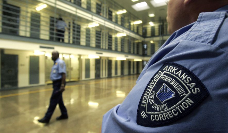 In this Aug. 10, 2009, file photo, guards patrol a cell block housing disruptive inmates at the Cummins Unit of the Arkansas Department of Correction near Varner, Ark. (AP Photo/Danny Johnston, File)