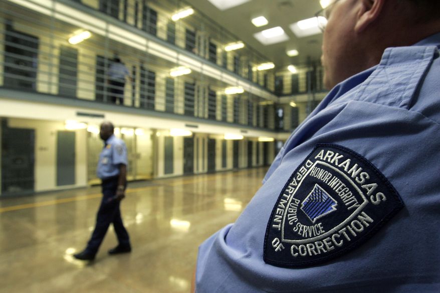 In this Aug. 10, 2009, file photo, guards patrol a cell block housing disruptive inmates at the Cummins Unit of the Arkansas Department of Correction near Varner, Ark. (AP Photo/Danny Johnston, File)