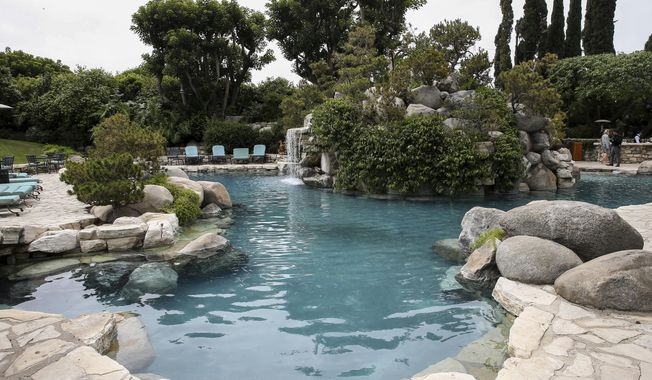 FILE - This May 11, 2016 file photo shows the pool area at the Playboy Mansion in Los Angeles. Hugh Hefner bought the Holmby Hills property in 1971 and turned it into the epicenter of his growing magazine and lifestyle enterprise. A neighbor bought the property for $100 million in 2016 with the stipulation that Hefner could live the rest of his years there. He died Wednesday at 91. (Photo by John Salangsang/Invision/AP, File)
