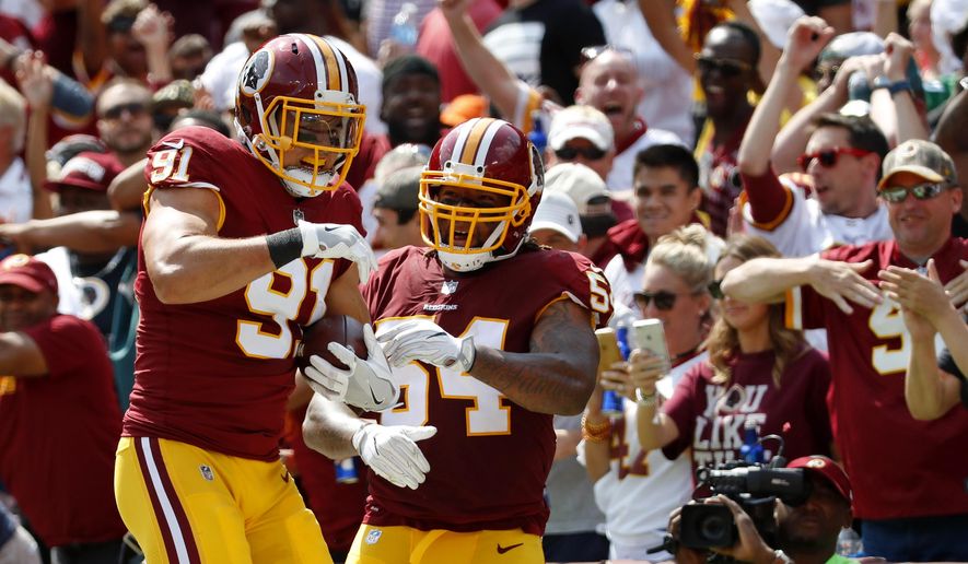 FILE - In this Sept. 10, 2017, file photo, Washington Redskins outside linebacker Ryan Kerrigan, left, celebrates with Mason Foster after running an interception back for a touchdown in the first half of an NFL football game against the Philadelphia Eagles in Landover, Md. The Redskins bring the league’s fifth-rated defense into Kansas City after it held the Raiders to 128 yards total offense last week. (AP Photo/Alex Brandon, File)