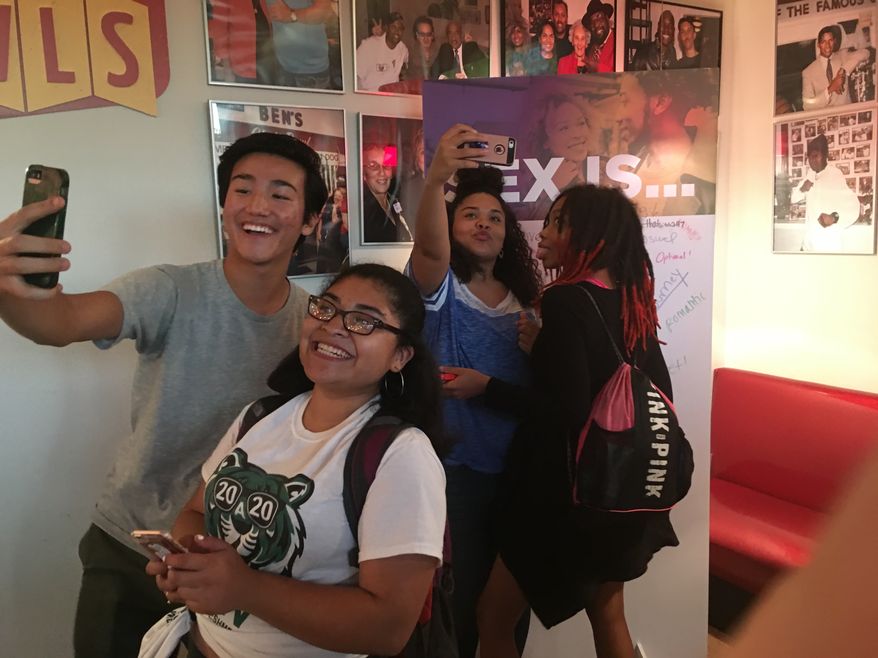 D.C. high school students take photos in front of a "Sex is..." campaign as part of the Department of Health's initiative to promote safe sex and open conversation about pregnancy, STDs and HIV/AIDS. (By Laura Kelly/The Washington Times)