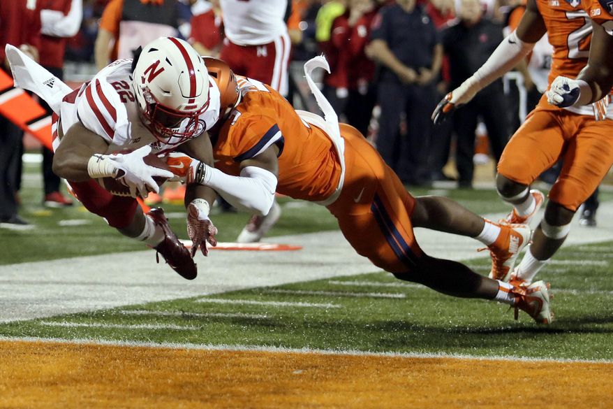Nebraska running back Devine Ozigbo (22) dives into the end zone for a touchdown against Illinois linebacker Del'Shawn Phillips (3) during the first half of an NCAA college football game Friday, Sept. 29, 2017, in Champaign, Ill. (AP Photo/Stephen Haas)