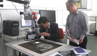 In this photo provided by the Conde museum, Chateau de Chantilly, and dated Wednesday, Sept. 27, 2017, chief curator of heritage, Bruno Mottin, left, examines a charcoal sketch through a microscope, depicting a nude woman while Mathieu Deldicque, curator at Conde museum, looks on, at the Center for Research and Restoration of the Museums of France in Paris, France. There&#39;s something vaguely familiar about this charcoal sketch of a woman&#39;s face and nude torso _ could it be an unclothed precursor to the Mona Lisa? (Domaine de Chantilly via AP)