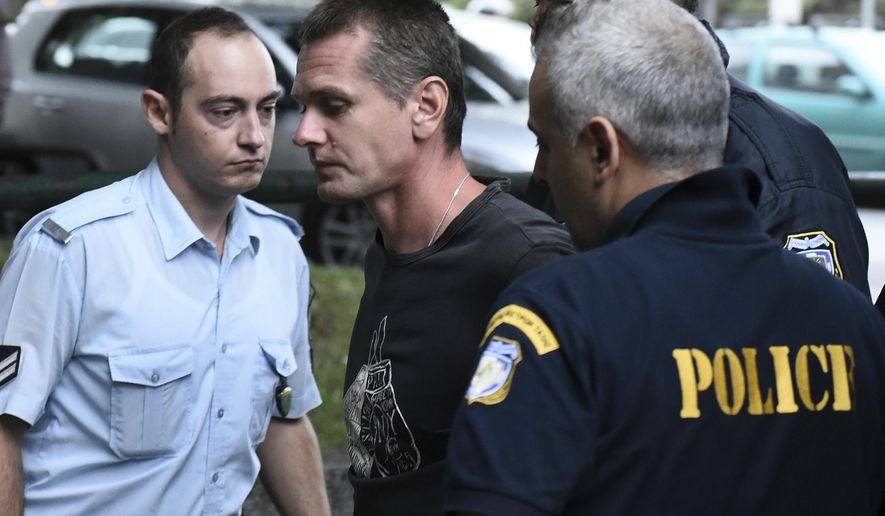 A Russian man identified as Alexander Vinnik, center, is escorted by police officers to the courthouse at the northern Greek city of Thessaloniki on Friday, Sept. 29, 2017. The Russian cybercrime suspect Alexander Vinnik, is wanted in the United States in a $4 billion bitcoin fraud case as Russia wants to extradite him as well on separate fraud charges. (AP Photo/Giannis Papanikos)
