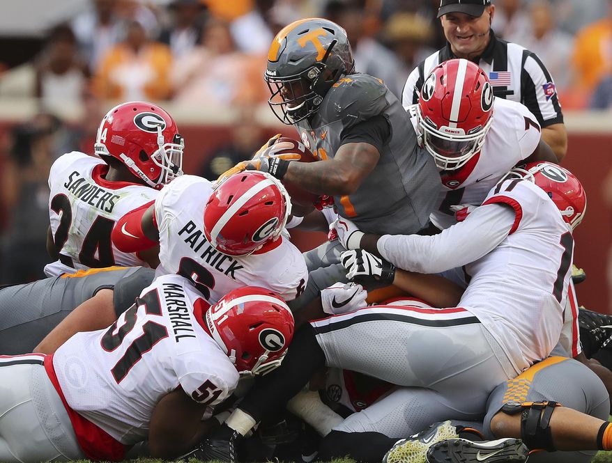 Georgia defenders David Marshall (51),  Natrez Patrick (6), Dominick Sanders (24), Lorenzo Carter (7) and Davin Bellamy (17) gang tackle Tennessee running back John Kelly at the line of scrimmage for no gain during the first half of an NCAA college football game against Tennessee on Saturday, Sept. 30, 2017, in Knoxville, Tenn. (Curtis Compton/Atlanta Journal-Constitution via AP)