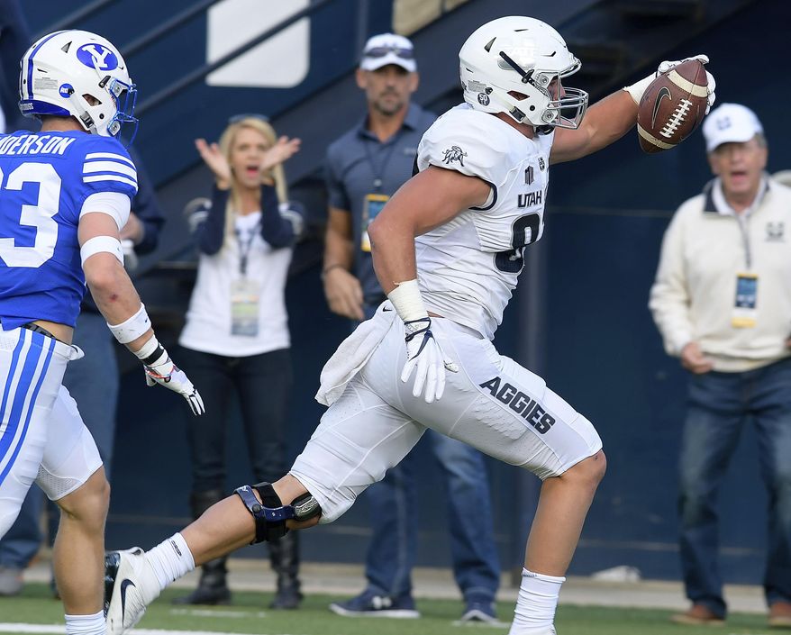 Utah State tight end Dax Raymond (87) celebrates as he scores a touchdown in front of BYU defensive back Zayne Anderson during an NCAA college football game, Friday, Sept. 29, 2017, in Logan, Utah. (Eli Lucero/Herald Journal via AP)