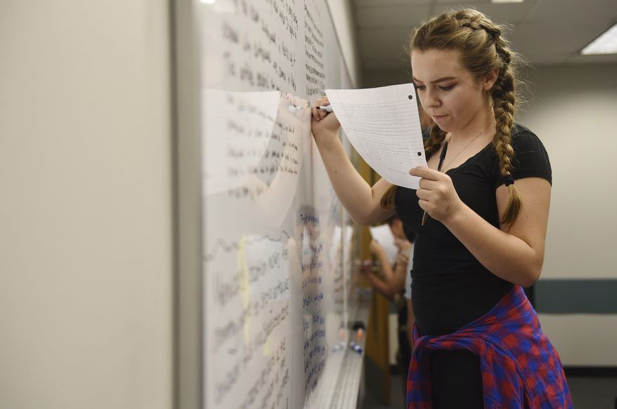 In this Friday, Sept. 22, 2017 photo, a student works at the white board during ninth grade English class in Porter Building at Eastern Michigan University, near Ann Arbor, Mich. The Early College Alliance at EMU has expanded to include a new ninth grade academy this school year. (Melanie Maxwell /The Ann Arbor News via AP)