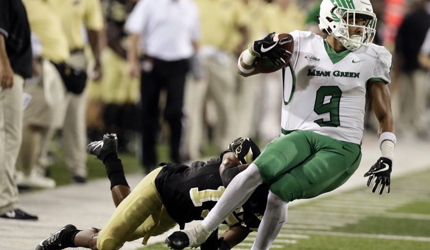 North Texas wide receiver Jaylen Guyton (9) is brought down by a Southern Mississippi defensive back Curtis Mikell (19) following a third quarter pass reception for a first down during their NCAA college football game in Hattiesburg, Miss., Saturday, Sept. 30, 2017. North Texas won 43-28. (AP Photo/Rogelio V. Solis)