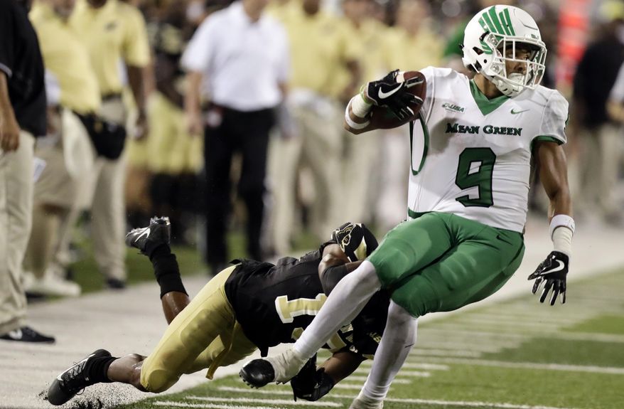 North Texas wide receiver Jaylen Guyton (9) is brought down by a Southern Mississippi defensive back Curtis Mikell (19) following a third quarter pass reception for a first down during their NCAA college football game in Hattiesburg, Miss., Saturday, Sept. 30, 2017. North Texas won 43-28. (AP Photo/Rogelio V. Solis)