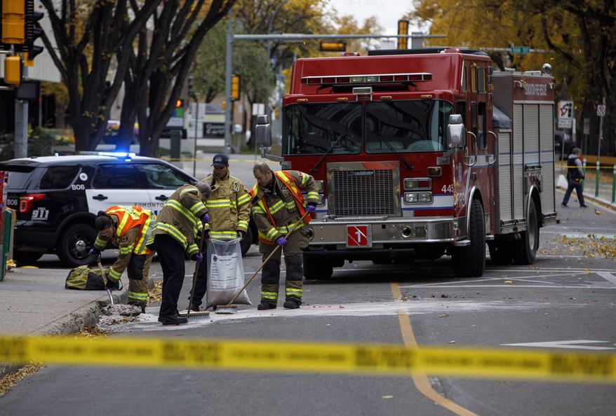 Crews clean up the scene where a van ran into pedestrians and later flipped over Saturday while being pursued by police, in Edmonton Alta, on Sunday, Oct. 1, 2017. The car and knife attack on a police officer outside a football game and a high-speed chase of a moving van that left four people injured appear to be the work of a single suspected terrorist, Canadian authorities said Sunday.(Jason Franson/The Canadian Press via AP)