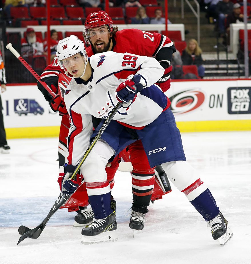 Washington Capitals' Alex Chiasson (39) battles Carolina Hurricanes' Justin Faulk (27) during the second period of an NHL hockey game, Friday, Sept. 29, 2017, in Raleigh, N.C. (AP Photo/Karl B DeBlaker)