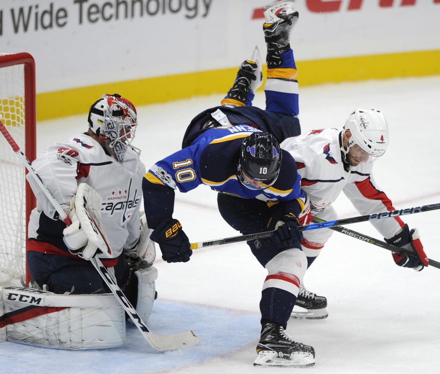 Washington Capitals' Taylor Chorney (4) checks St. Louis Blues' Brayden Schenn (10) as Capitals' Braden Holtby (70) looks on during the first period of a preseason NHL hockey game, Sunday, Oct. 1, 2017, in St. Louis. (AP Photo/Bill Boyce)