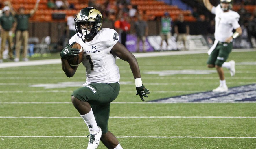 As Colorado State quarterback Nick Stevens (7) reacts in the background, wide receiver Michael Gallup (4) runs the ball in for a third quarter touchdown against Hawaii at the NCAA college football game, Saturday, Sept. 30, 2017, in Honolulu. (AP Photo/Marco Garcia)