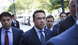 FILE- In this July 17, 2015 file photo, former U.S. Rep. Michael Grimm, center, arrives ahead of his sentencing at federal court in the Brooklyn borough of New York. Grimm, who went to prison for tax fraud and once threatened to throw a TV reporter off a balcony, is set to announce Sunday, Oct. 1, 2017, that he will try to reclaim his old seat in Congress. (AP Photo/Kevin Hagen, File)