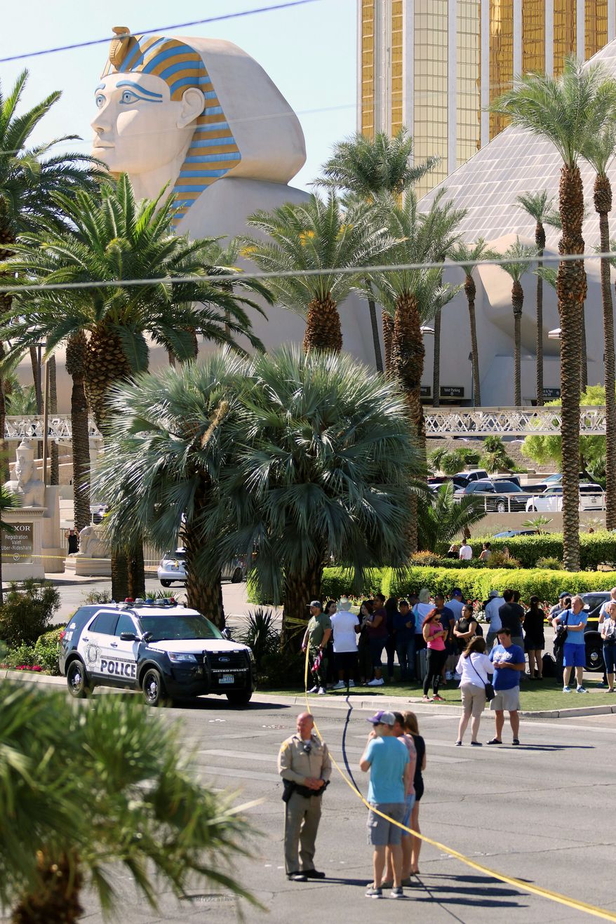 People gathered Monday at the scene of the mass shooting on the Las Vegas Strip the night before. Authorities are investigating the gunman's motive for the attack and the types of weapons used. (Associated Press)