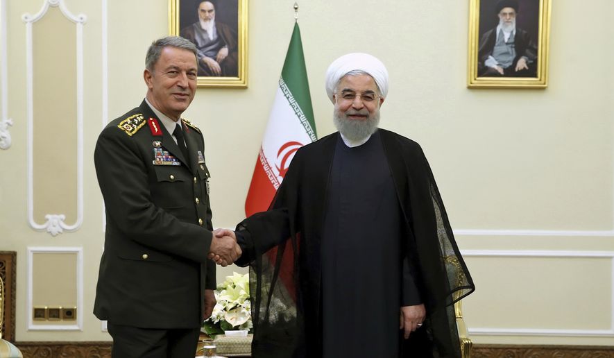 In this photo released by an official website of the office of the Iranian Presidency, President Hassan Rouhani, right, shakes hands with Turkey&#39;s Chief of Staff Gen. Hulusi Akar, in Tehran, Iran, Monday, Oct. 2, 2017. (Iranian Presidency Office via AP)