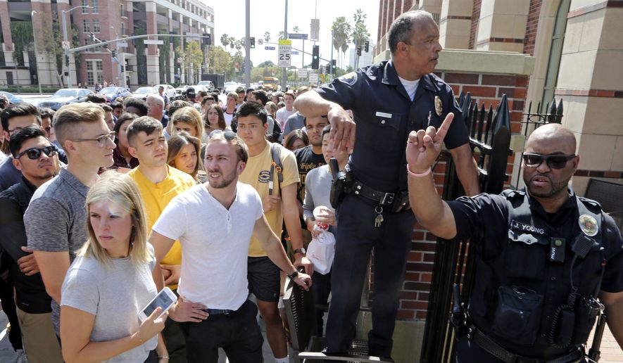 University police officers prepare to readmit students to retrieve belongings after they were escorted from a building at the University of Southern California while police made a floor-by-floor sweep after a report of shooting on the campus in downtown Los Angeles Monday, Oct. 2, 2017. Authorities said they found no evidence of a shooting on the campus and there is no danger to the university or the community. (AP Photo/Reed Saxon)