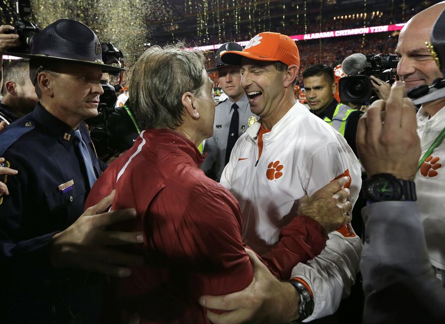 FILE - In this Jan. 11, 2016, file photo, Clemson head coach Dabo Swinney, right, congratulates Alabama head coach Nick Saban after the Crimson Tide won 45-40 in the NCAA college football playoff championship game in Glendale, Ariz. One month into the college season and it already seems as if all roads are leading to another Alabama-Clemson championship game. Clemson once again grabbed first-place votes from preseason No. 1 Alabama in Sunday’s new AP Top 25. (AP Photo/David J. Phillip, FIle)