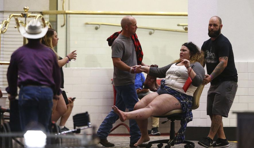A wounded woman is moved outside the Tropicana during an active shooter situation on the Las Vegas Strip in Las Vegas Sunday, Oct. 1, 2017. Multiple victims were being transported to hospitals after a shooting late Sunday at a music festival on the Las Vegas Strip. (Chase Stevens/Las Vegas Review-Journal via AP)