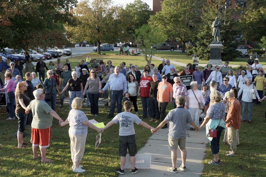 FILE - In this Sept. 12, 2017, file photo, a chorus of "We Shall Overcome" rises from a gathering against racism in Broad Street Park in Claremont, N.H. The demonstration was inspired by violence in August against an 8-year-old biracial boy that occurred while he played with a group of teenagers outside his home. The incident has prompted people in the town to reflect and assess how it handles the issue of race in this mostly white community. (James M. Patterson/The Valley News via AP, File)