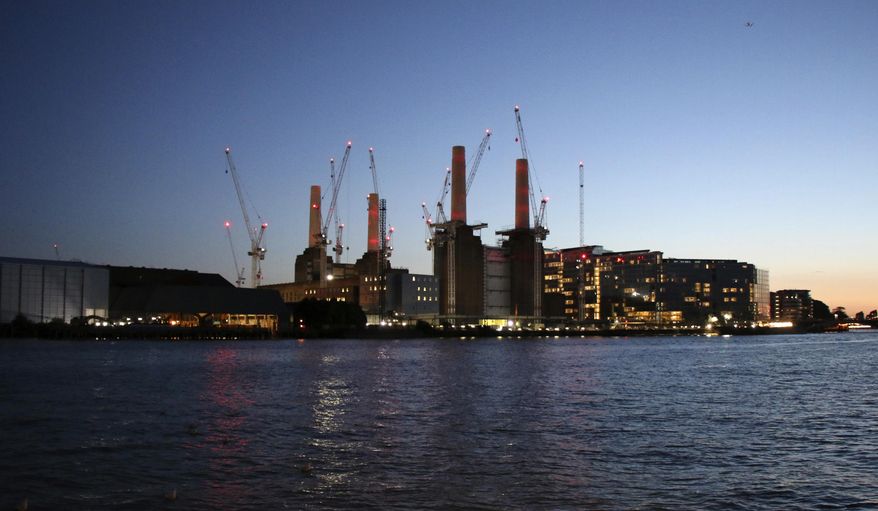 In this photo taken Sept. 13, 2017, cranes surround the Battersea Power Station in London as work continues. A once derelict building, made famous by Pink Floyd and Batman, is finally being re-developed after decades of failed schemes. Towering over the River Thames, the landmark Battersea Power Station is the centerpiece of a dramatic new residential and office development that will include 4,000 homes, retail shops, tourist attractions as well as Apple’s London headquarters. (AP Photo/Leonore Schick)