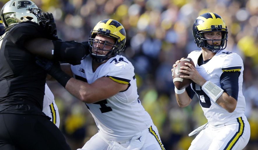 FILE - In this Saturday, Sept. 23, 2017, file photo, Michigan quarterback John O'Korn (8) looks to pass during the first half of an NCAA college football game against Purdue in West Lafayette, Ind. Seventh-ranked Michigan has lost quarterback Wilton Speight for multiple weeks with an undisclosed injury. Coach Jim Harbaugh said Monday, Oct. 2, 2017, that John O’Korn will start Saturday night when the Wolverines play against Michigan State.(AP Photo/Michael Conroy, File)