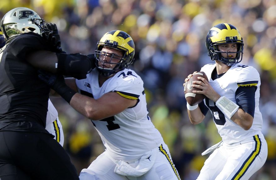 FILE - In this Saturday, Sept. 23, 2017, file photo, Michigan quarterback John O'Korn (8) looks to pass during the first half of an NCAA college football game against Purdue in West Lafayette, Ind. Seventh-ranked Michigan has lost quarterback Wilton Speight for multiple weeks with an undisclosed injury. Coach Jim Harbaugh said Monday, Oct. 2, 2017, that John O’Korn will start Saturday night when the Wolverines play against Michigan State.(AP Photo/Michael Conroy, File)