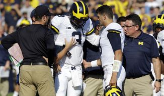 FILE - In this Saturday, Sept. 23, 2017, file photo, Michigan quarterback Wilton Speight (3) is helped off the field after getting injured in the first half of an NCAA college football game against Purdue in West Lafayette, Ind. Seventh-ranked Michigan has lost quarterback Wilton Speight for multiple weeks with an undisclosed injury. Coach Jim Harbaugh said Monday, Oct. 2, 2017, that John O’Korn will start Saturday night when the Wolverines play against Michigan State. (AP Photo/Michael Conroy, File)