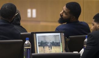 Marcus Morris, left, Markieff Morris, center, and Gerald Bowman, right, attend during closing arguments Monday, Oct. 2, 2017, in Maricopa County Superior Court in Phoenix. The Morris brothers are accused of helping three other people beat Erik Hood two years ago. (Mark Henle/The Arizona Republic via AP)