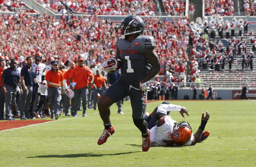 North Carolina State's Jaylen Samuels (1) beats Syracuse linebacker Zaire Franklin (4) to score on 16-yard touchdown run during the first half of an NCAA college football game at Carter-Finley Stadium in Raleigh, N.C., Saturday, Sept. 30, 2017. (Ethan Hyman/The News & Observer via AP)
