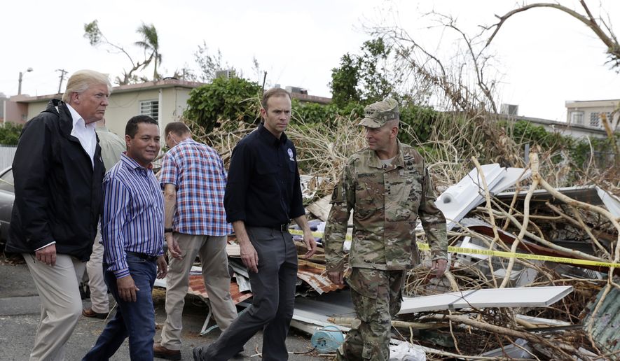President Donald Trump takes a walking tour to survey hurricane damage and recovery efforts in a neighborhood in Guaynabo, Puerto Rico, Tuesday, Oct. 3, 2017. (AP Photo/Evan Vucci) **FILE**
