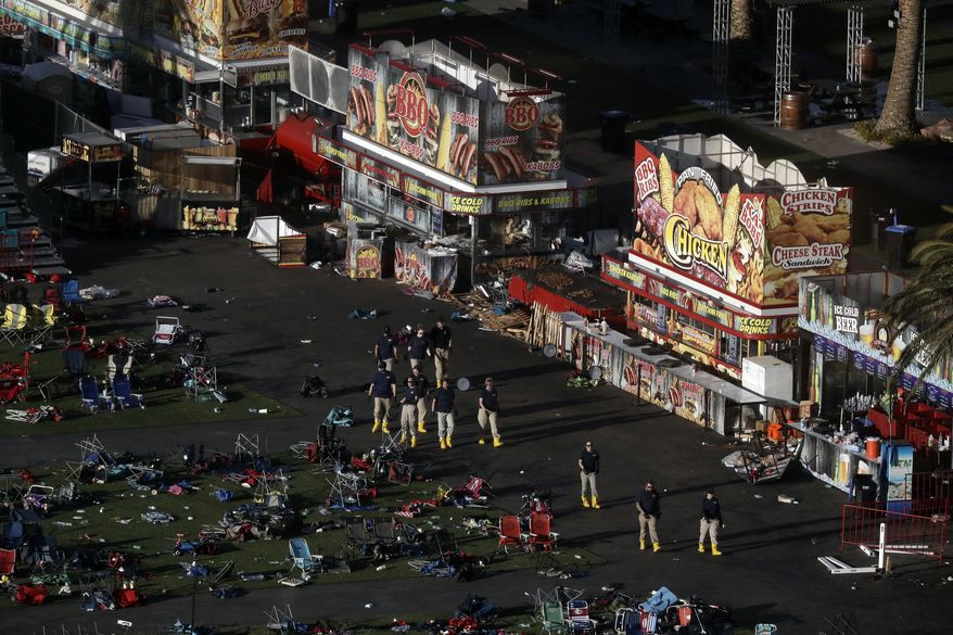 Investigators work at a festival grounds across the street from the Mandalay Bay Resort and Casino on Tuesday, Oct. 3, 2017, in Las Vegas. Authorities said Stephen Craig Paddock broke windows on the casino and began firing with a cache of weapons, killing dozens and injuring hundreds at the music festival on Sunday. (AP Photo/Marcio Jose Sanchez)