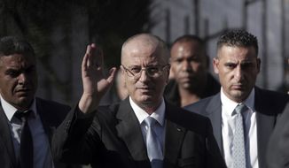 Palestinian Prime Minister Rami Hamdallah waves to the media as he arrives to head the Cabinet session in Palestinian President Mahmoud Abbas&#39; former official resident in Gaza City, Tuesday, Oct. 3, 2017. Hamdallah has held the first government meeting in the Gaza Strip as part of a major reconciliation effort to end the 10-year rift between Fatah and Hamas. (AP Photo/ Khalil Hamra)