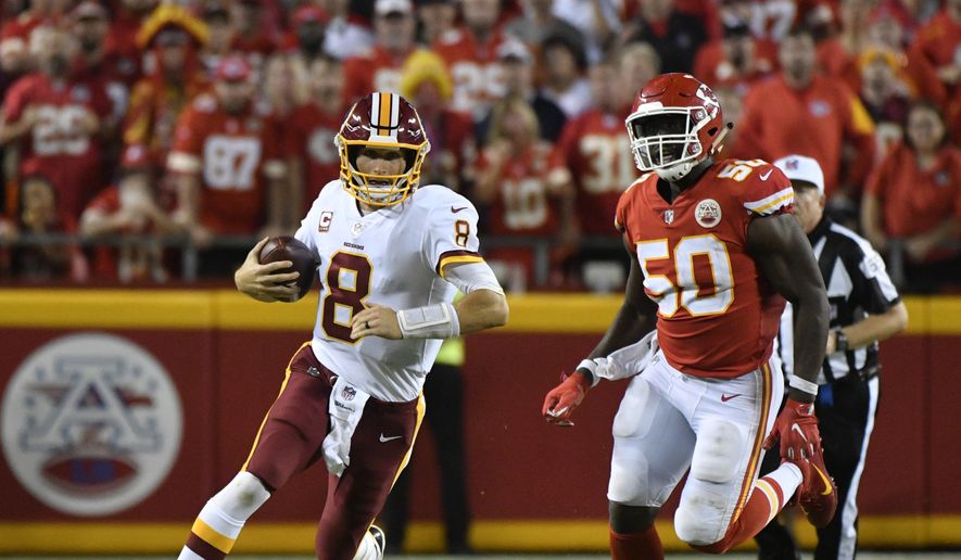 Washington Redskins quarterback Kirk Cousins (8) carries the ball between Kansas City Chiefs defensive back Terrance Mitchell (39) and linebacker Justin Houston (50) during the second half of an NFL football game in Kansas City, Mo., Monday, Oct. 2, 2017. The Kansas City Chiefs won 29-20. (AP Photo/Ed Zurga)