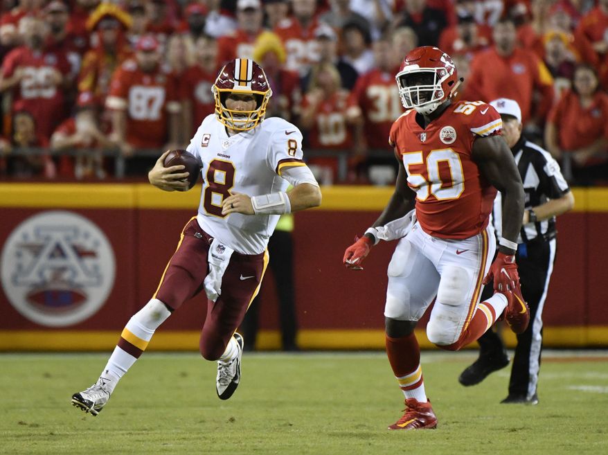 Washington Redskins quarterback Kirk Cousins (8) carries the ball between Kansas City Chiefs defensive back Terrance Mitchell (39) and linebacker Justin Houston (50) during the second half of an NFL football game in Kansas City, Mo., Monday, Oct. 2, 2017. The Kansas City Chiefs won 29-20. (AP Photo/Ed Zurga)
